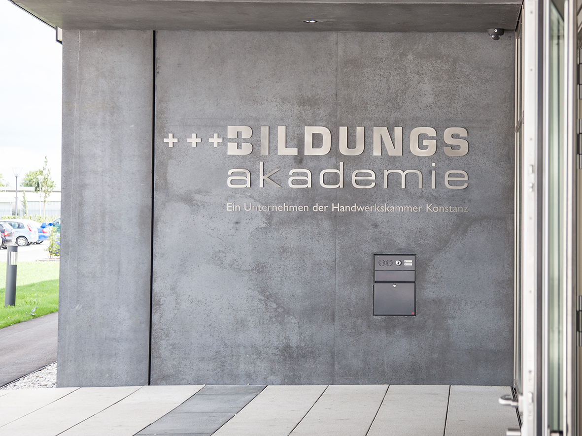 Schriftzug Bildungsakademie - Ein Unternehmen der Handwerkskammer Konstanz an der Fassade im Eingangsbereich der Bildungsakademie Singen.