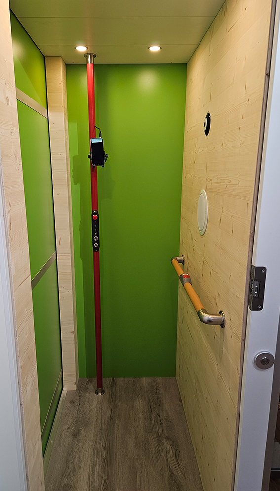 Individuelle Ausführung des Lifts mit grünen Innenwänden und Haltegriffen.