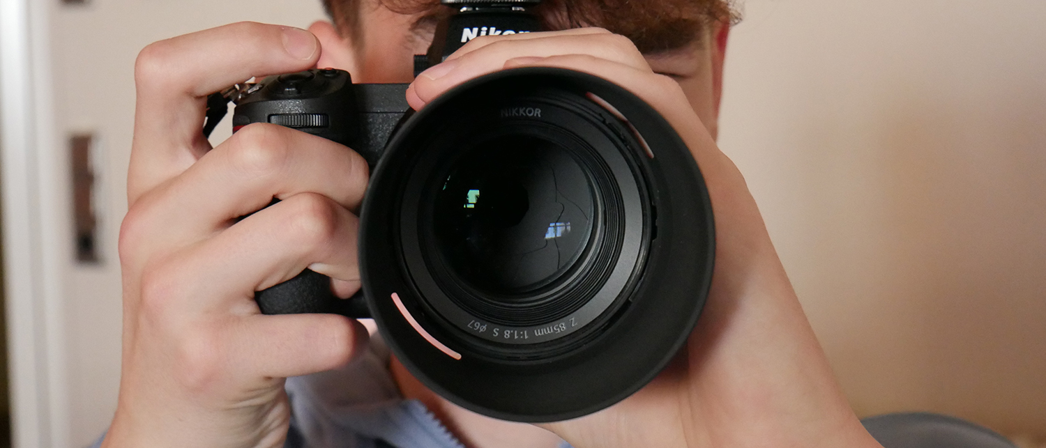 Ein Junge schaut durch einen Fotoapparat.