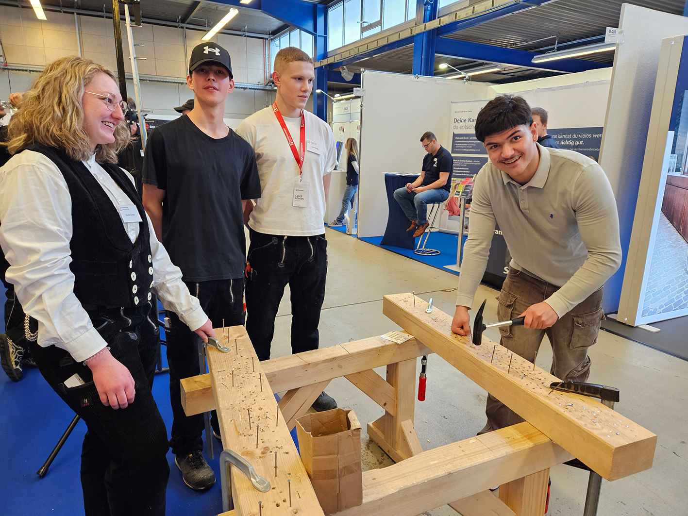Jobs for Future 2025: Schüler schlägt Nagel in Holzbalken am Stand einer Zimmerin.