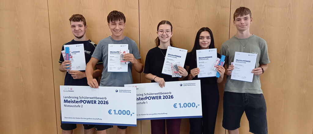 Gruppenbild: Drei Schüler und zwei Schülerinnen mit Urkunden und zwei großen Schecks in der Hand.