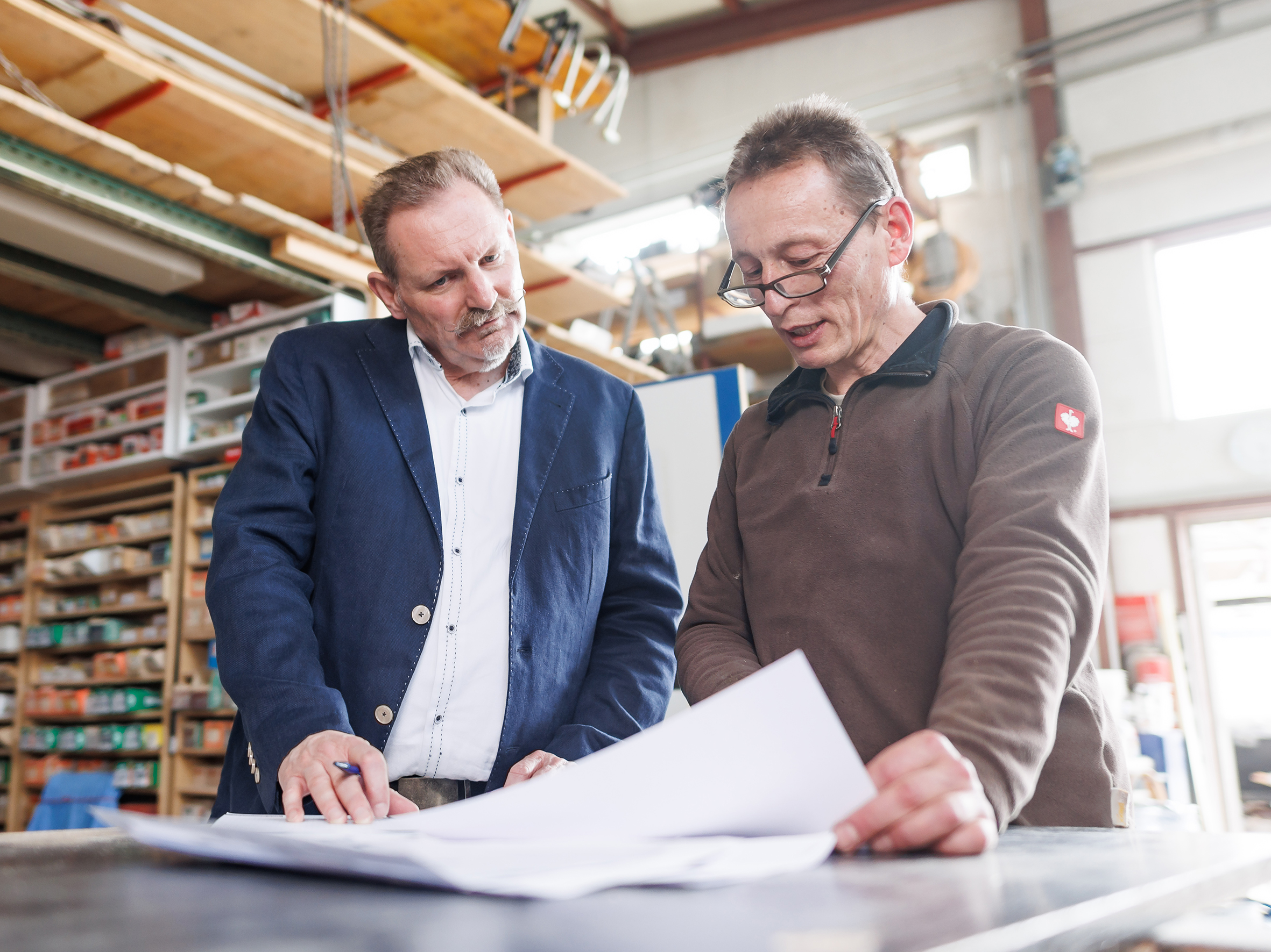 Umweltschutzberater Peter Schürmann im Gespräch mit einem Schreiner in dessen Werkstatt.