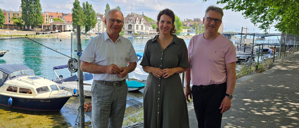 Werner Rottler, Sina Seitzl und Georg Hiltner stehen am Seerhein vor der Handwerkskammer Konstanz.