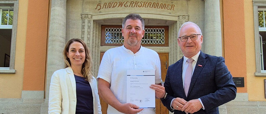 Gruppenbild: Der neu vereidigte Sachverständige Gerhard Schmidt mit Handwerkskammerpräsident Werner Rottler sowie HWK-Juristin Sandra Sorg vor der Handwerkskammer.