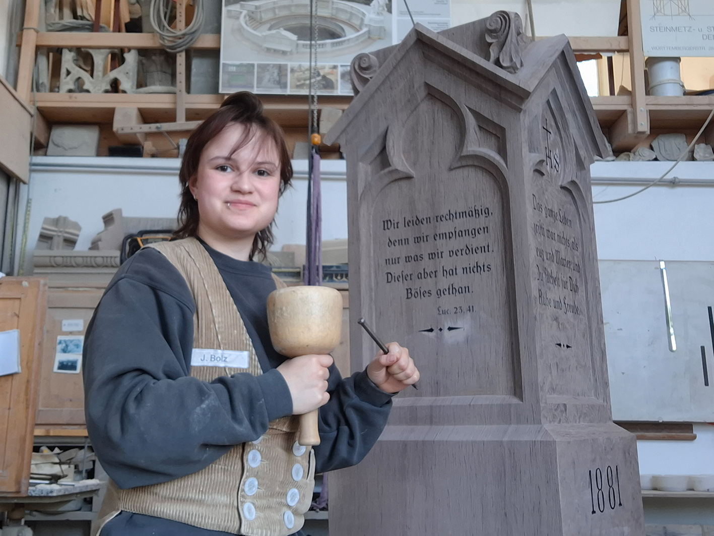 Jaime Bolz mit Werkzeug vor einem alten Grabstein.
