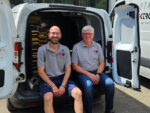 Ulrich Kammerer-Romano und Ralf Rapp sitzen im Firmen-Sprinter mit geöffneten Hintertüren.