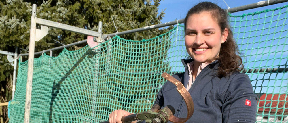 Klempnerin Julia Pfingst vor einem Gerüst.