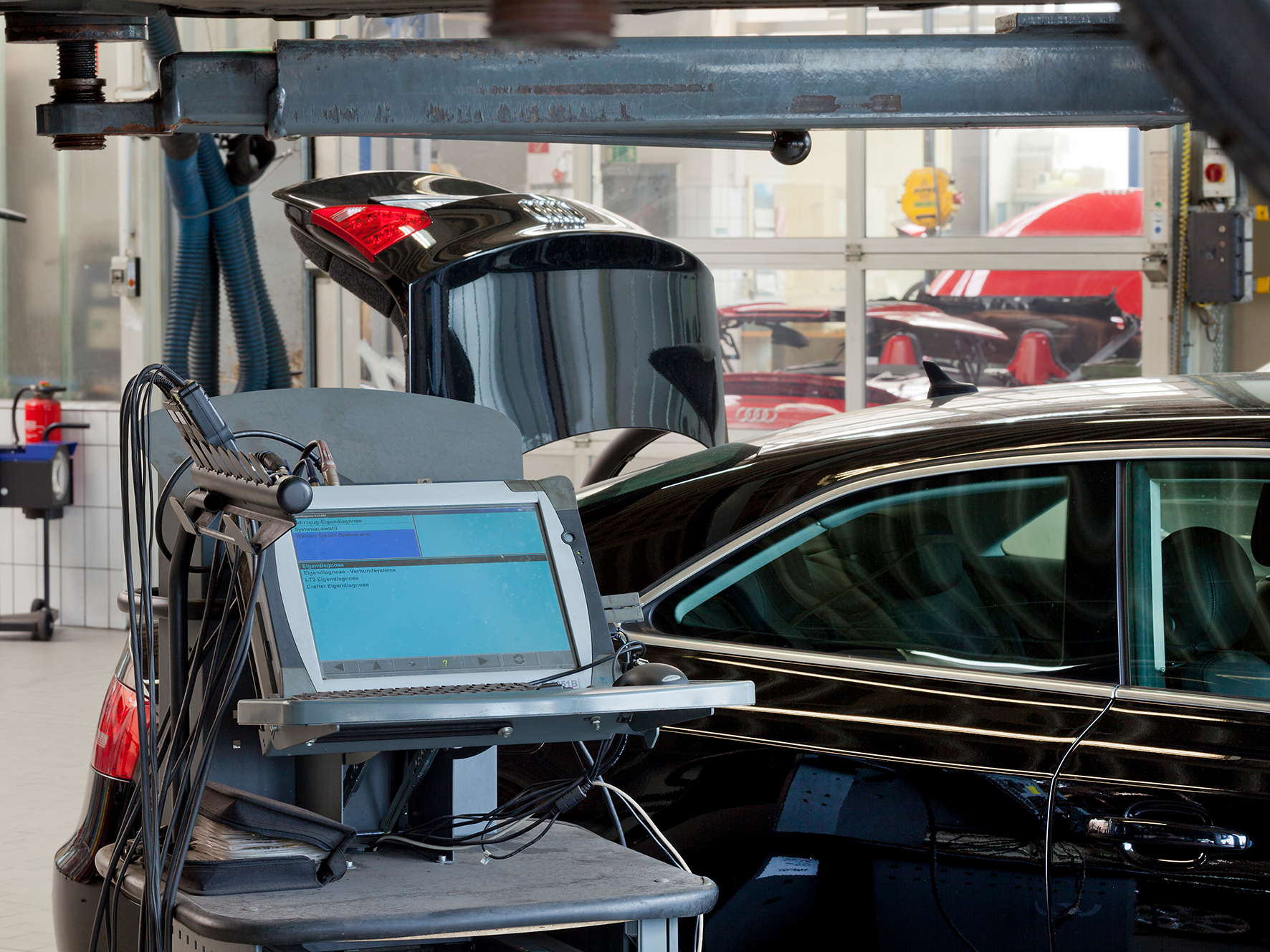 Auto mit geöffnetem Kofferraum in Werkstatt.
